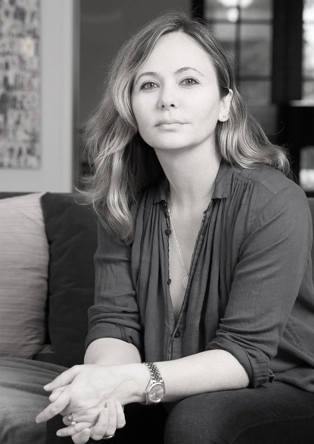 Black and white portrait of Naghmeh Shirkhan, seated, hands clasped.